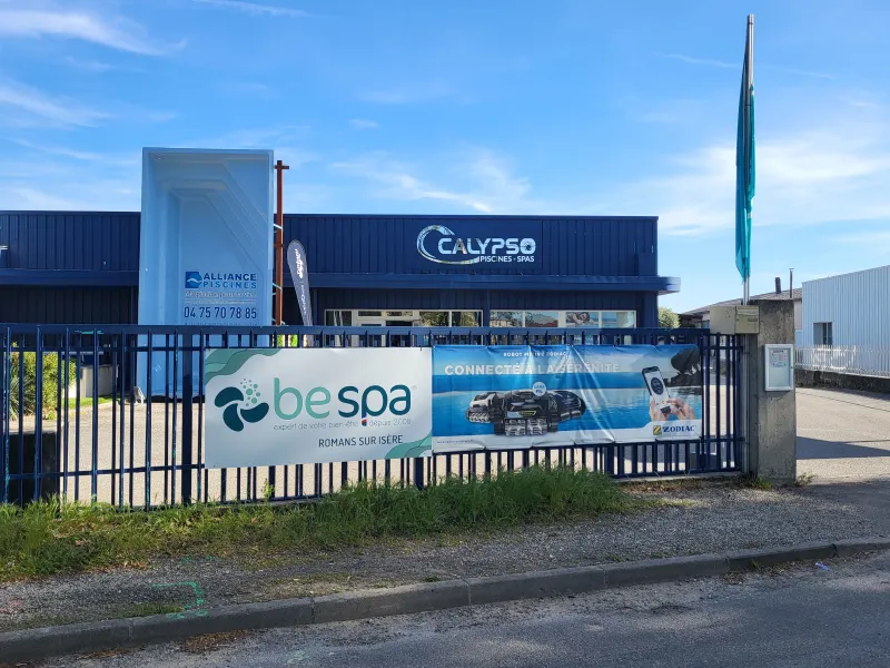 Vue extérieure du magasin Be Spa Calypso Piscines à Romans-sur-Isère, situé au 22 Avenue des Allobroges. La façade du magasin est visible avec le logo de Be Spa clairement affiché, invitant les clients à découvrir les produits pour piscines et spas.